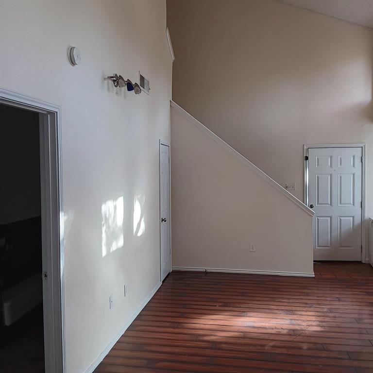 9254 Forest Lane, Unit 304 Dallas, TX 75243 - Photo 9 of 17 a view of an empty room with wooden floor and a window