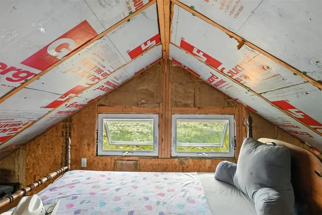 a view of a bedroom with a bed and a window