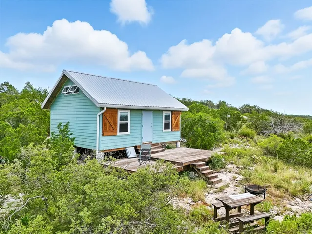 a backyard of a house with table and chairs