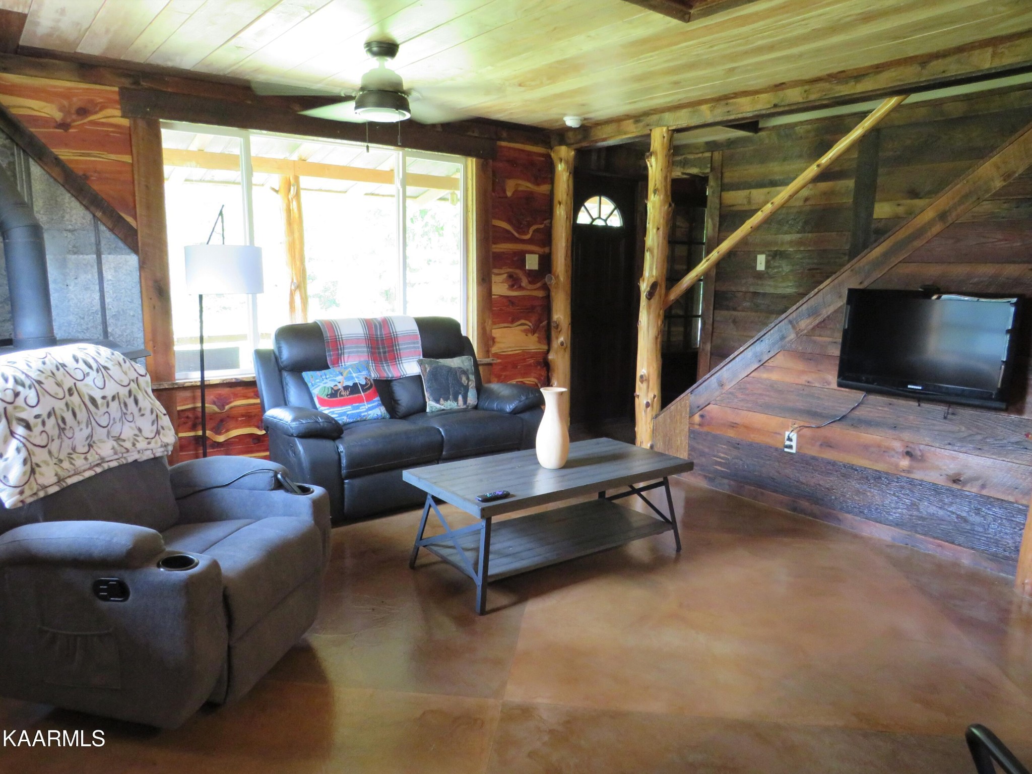 266 Ross Williams Road Lancing, TN 37770 - Photo 8 of 39 a living room with furniture a flat screen tv and a floor to ceiling window