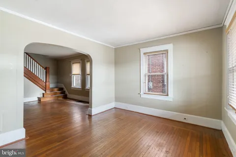 an empty room with wooden floor and a window