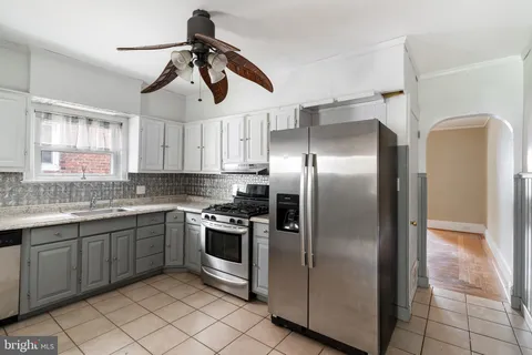 a kitchen with stainless steel appliances granite countertop a sink a stove a refrigerator and island