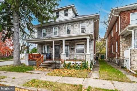 a front view of a house with garden and plants