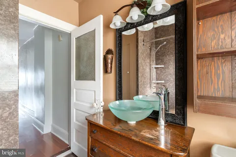 a bathroom with a granite countertop sink a toilet and shower