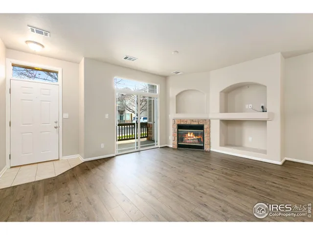 a view of an empty room with a fireplace and a window