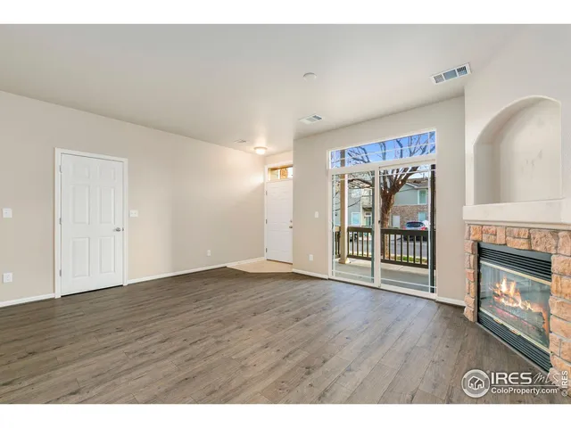 a view of an empty room with a fireplace and a window