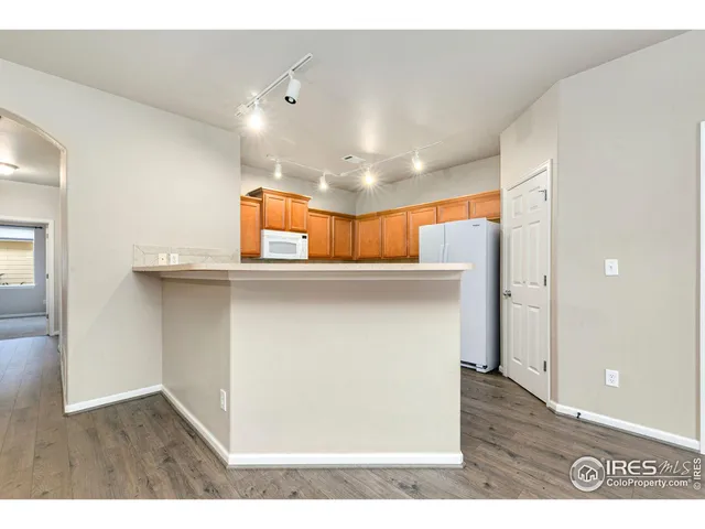 a kitchen with stainless steel appliances cabinets and wooden floor