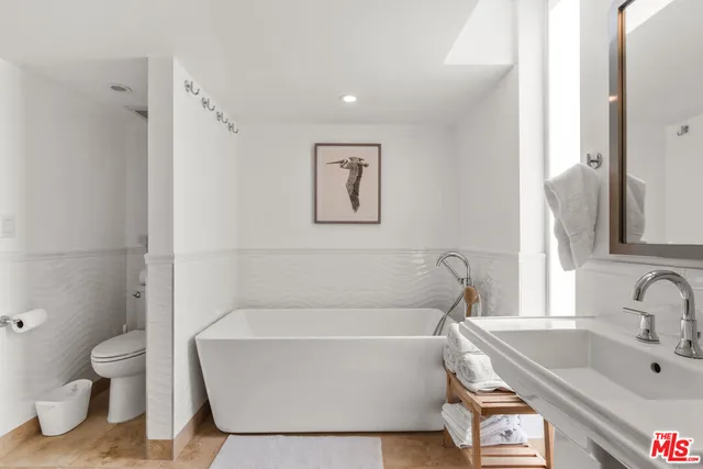 a white bath tub sitting next to a white toilet