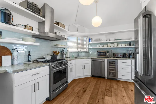 a kitchen with a white cabinets and wooden floor