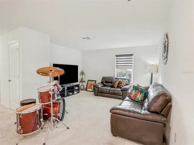 a bedroom with bed and a flat tv screen on dresser