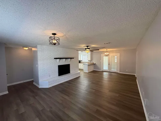 a view of a livingroom with wooden floor and a fireplace
