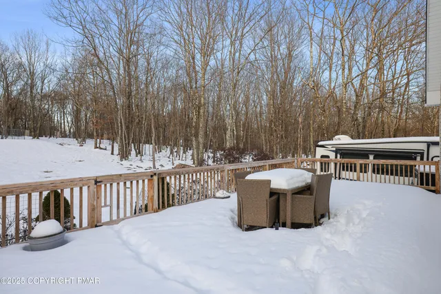 a view of a roof deck with couches and wooden fence