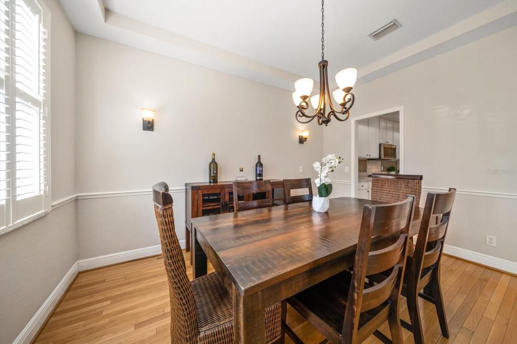 270 2nd Avenue Southwest Largo, FL 33770 - Photo 21 of 67 a dining room with wooden floor a chandelier a wooden table and chairs