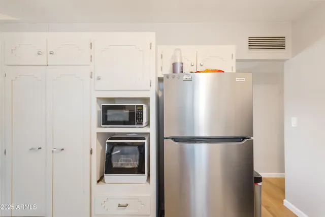 a white refrigerator freezer and a stove sitting inside of a kitchen