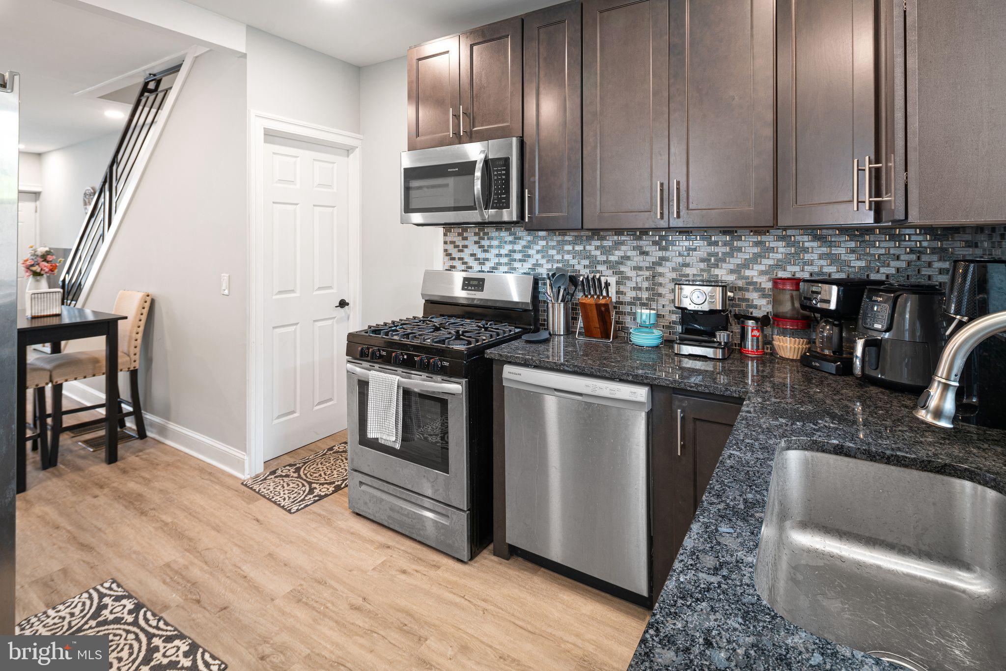 1920 Pierce Street Philadelphia, PA 19145 - Photo 6 of 17 a kitchen with granite countertop a stove a sink and a microwave