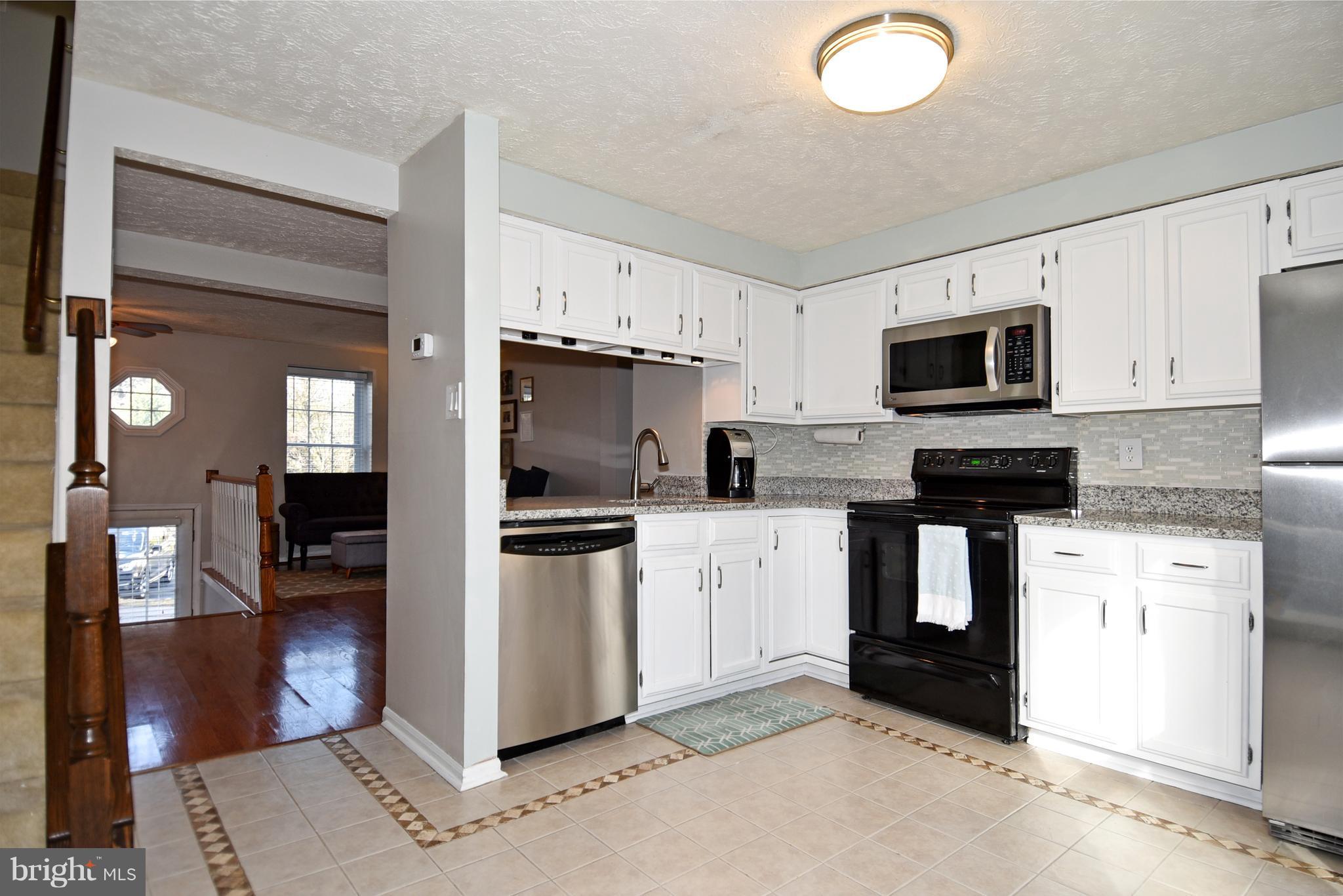 1615 Fieldthorn Drive Reston, VA 20194 - Photo 8 of 28 a kitchen with granite countertop a refrigerator stove and microwave