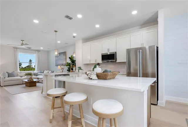 a kitchen with refrigerator and chairs
