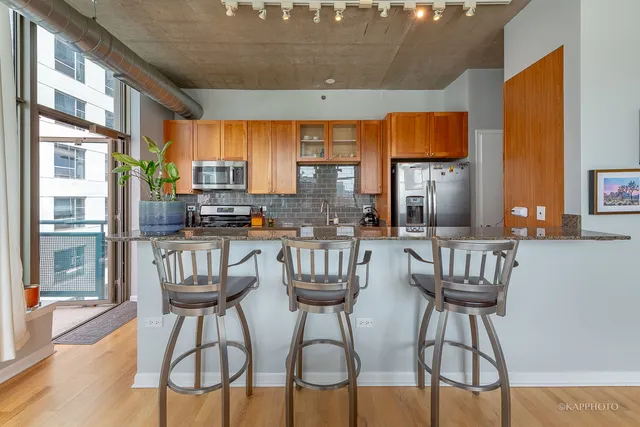 a view of a dining room with furniture a kitchen and chandelier