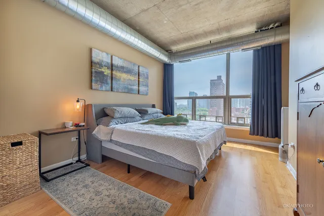 a bedroom with a bed and a large window