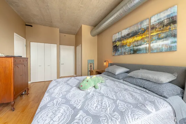 a bedroom with a large bed and wooden floor