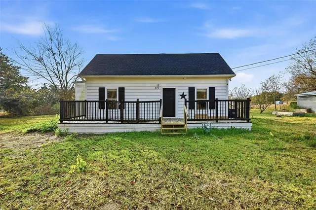 a view of a house with backyard and a tree