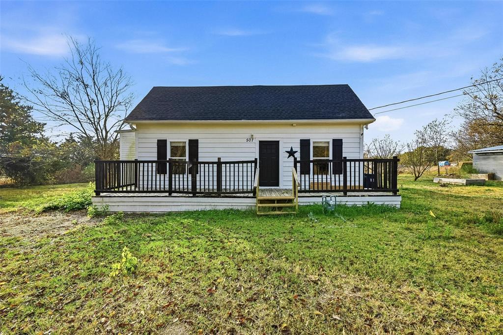 a view of a house with backyard and a tree