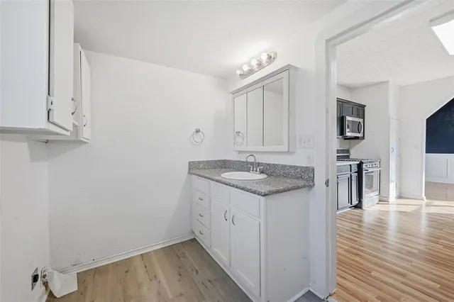 a kitchen with a sink cabinets and wooden floor