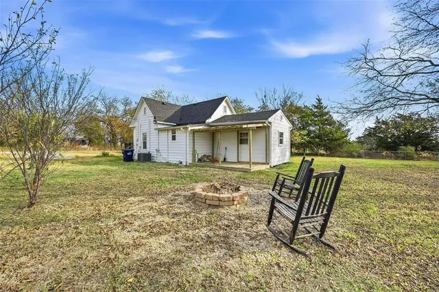 a view of a house with backyard and a trees