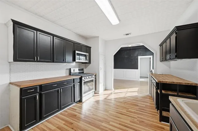 a kitchen with stainless steel appliances granite countertop a stove a sink and a microwave