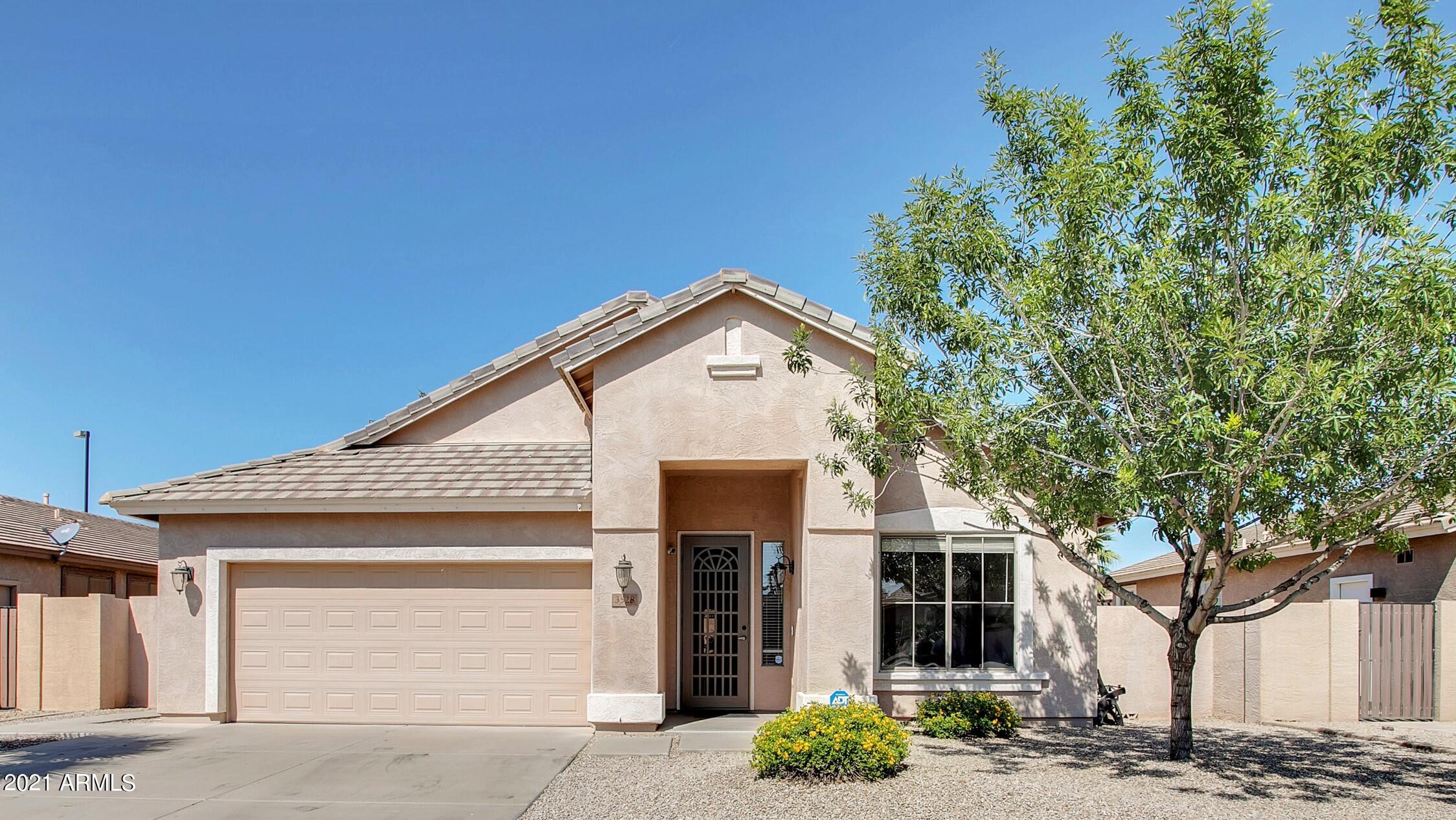 a view of a white house with a large tree