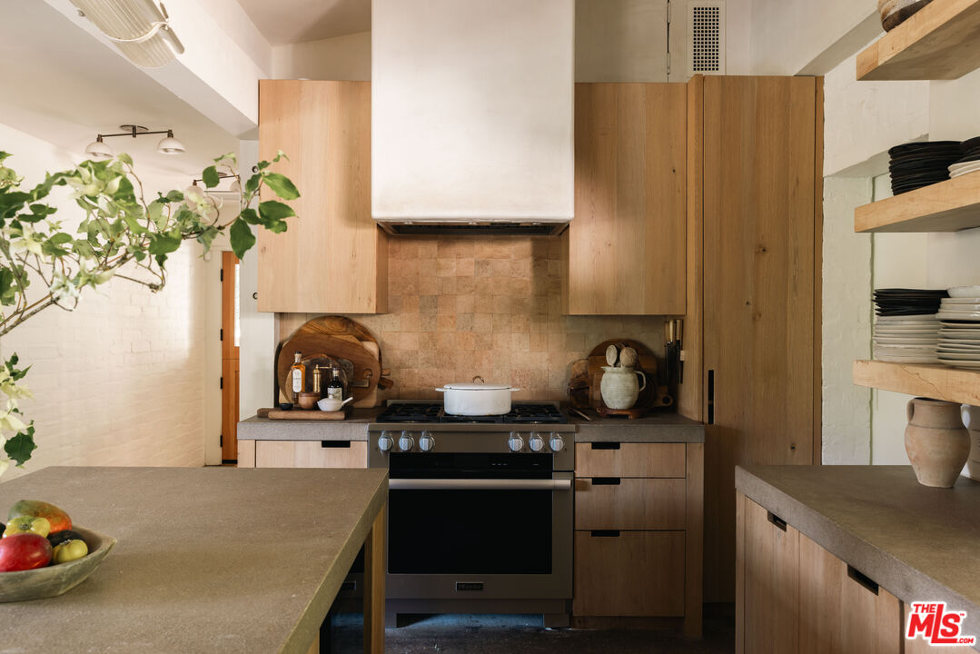 1830 Old Orchard Road Los Angeles, CA 90049 - Photo 5 of 30 a kitchen with stainless steel appliances a stove a refrigerator a sink a counter space and cabinets