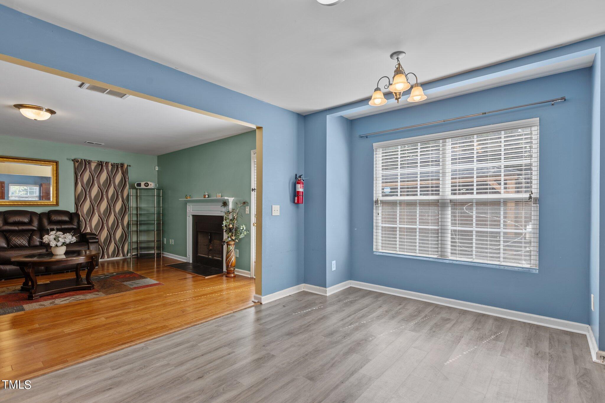 4232 Dalcross Road Raleigh, NC 27610 - Photo 12 of 38 a view of an empty room with a window and wooden floor