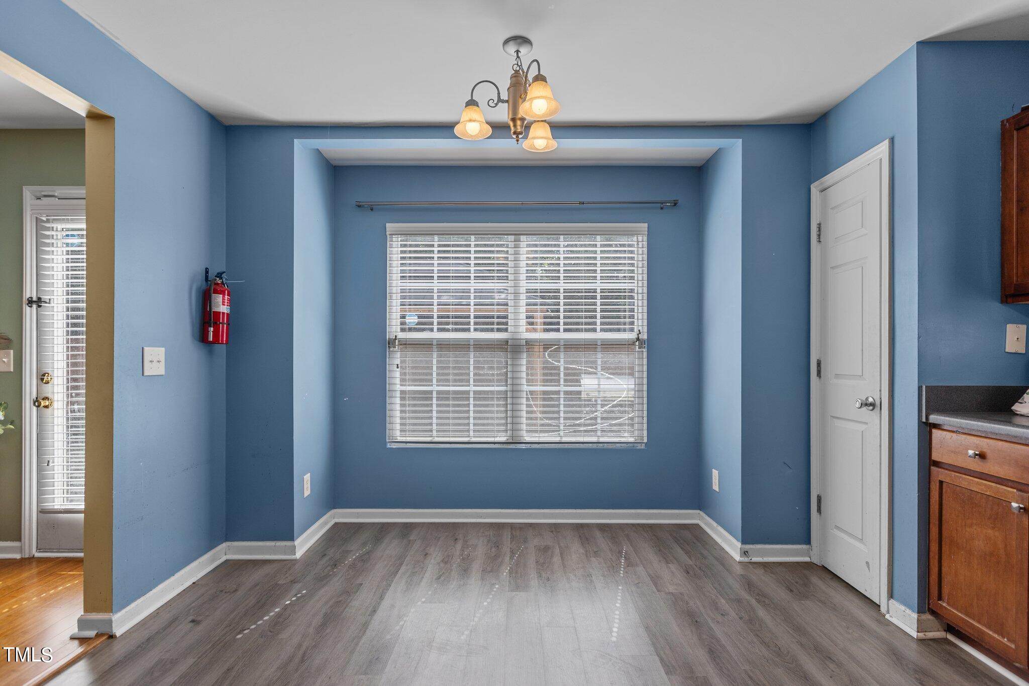 4232 Dalcross Road Raleigh, NC 27610 - Photo 13 of 38 a view of an empty room with wooden floor and a window