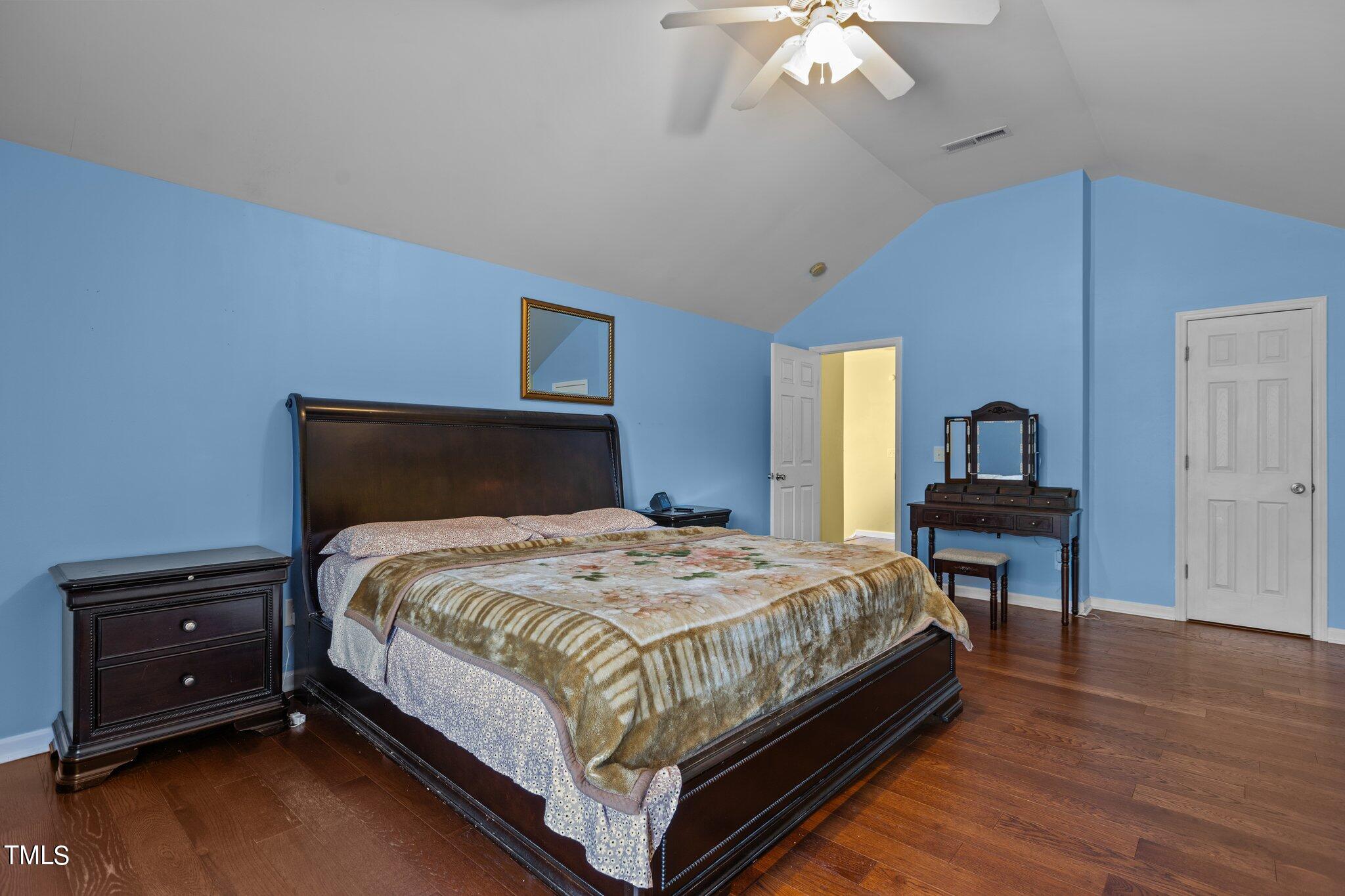 4232 Dalcross Road Raleigh, NC 27610 - Photo 21 of 38 a bedroom with a bed and a chandelier