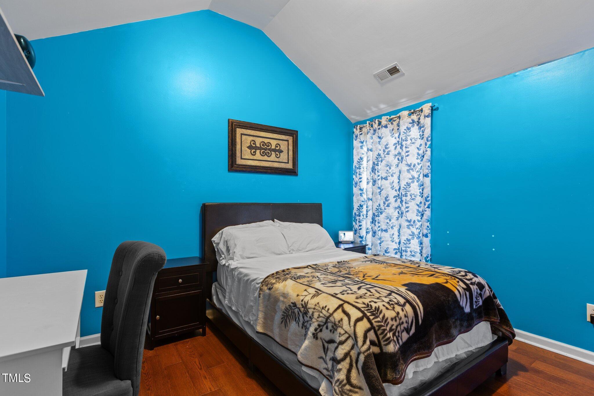 4232 Dalcross Road Raleigh, NC 27610 - Photo 29 of 38 a bed sitting in a bedroom next to a blue wall