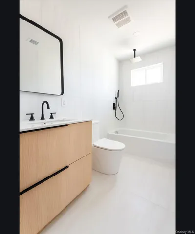 a bathroom with a toilet a sink and mirror