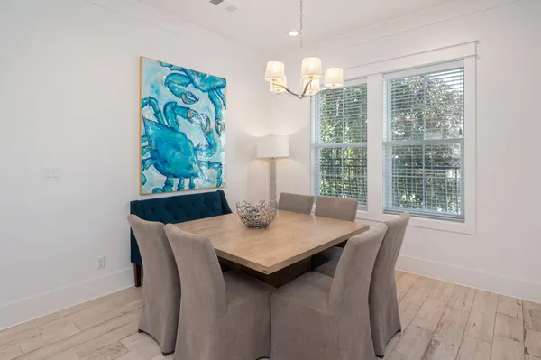 a view of a dining room with furniture a chandelier and wooden floor