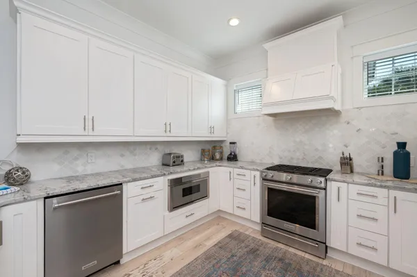 a kitchen with granite countertop white cabinets and a stove
