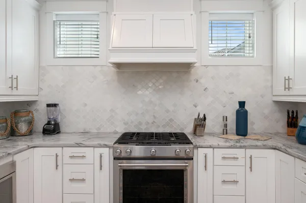 a kitchen with white cabinets and stainless steel appliances