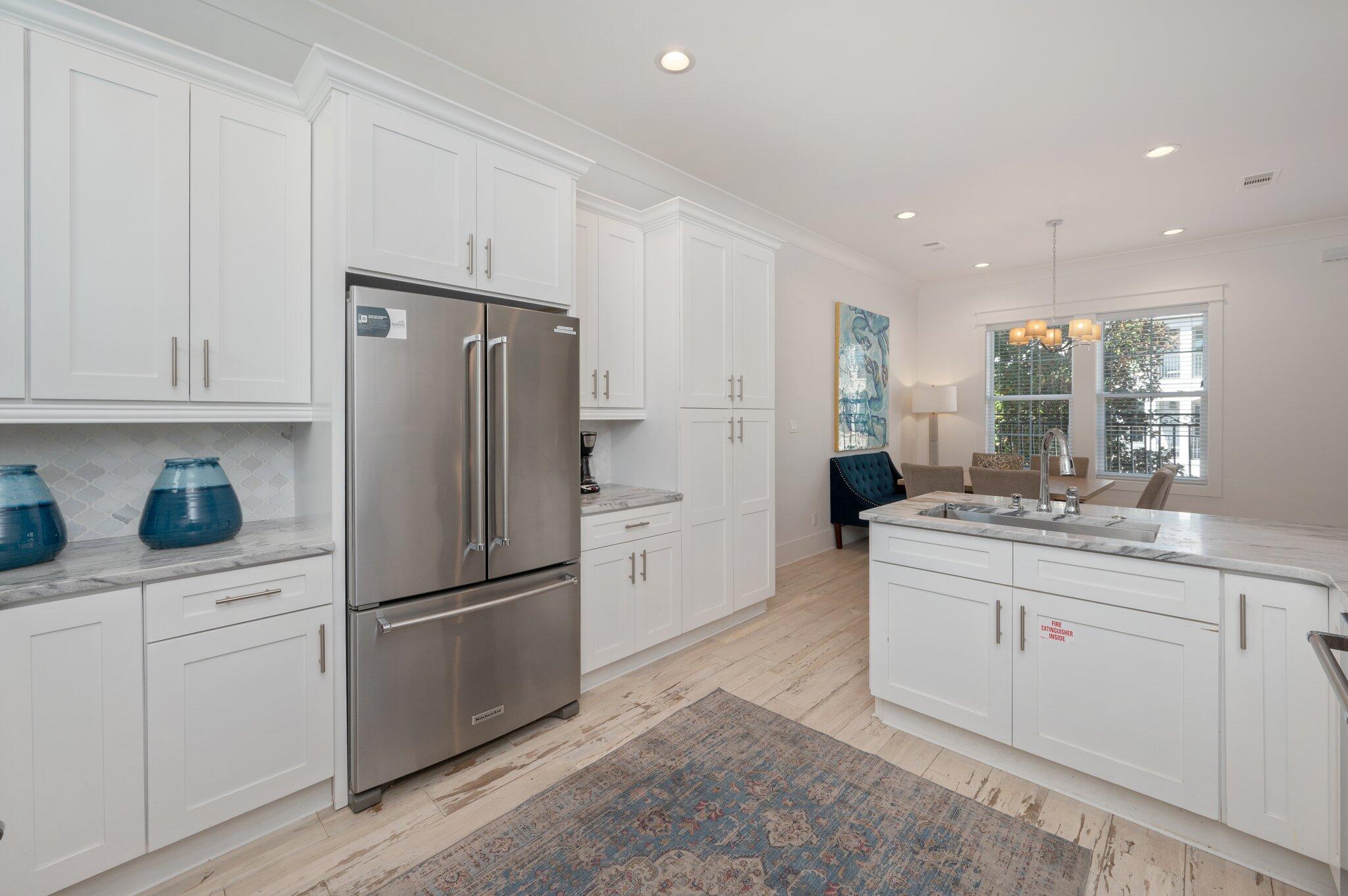 4795 Ocean Boulevard Destin, FL 32541 - Photo 21 of 50 a kitchen with white cabinets and stainless steel appliances