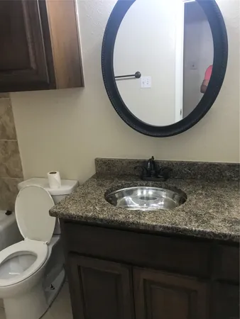 a bathroom with a granite countertop sink and a mirror