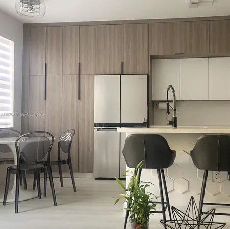 a kitchen with a sink and chairs