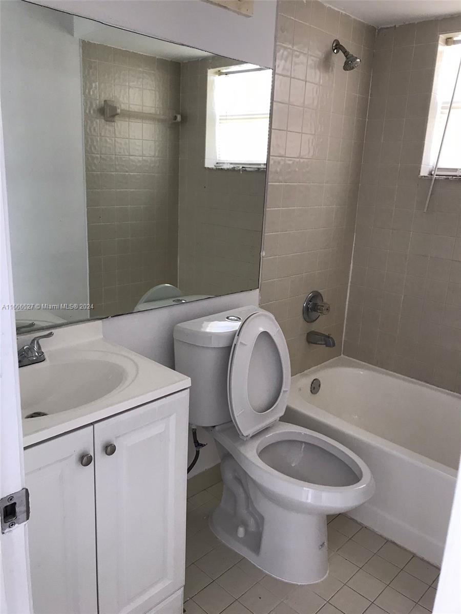 459 Northeast 210th Cir Terrace, Unit 20117 Miami, FL 33179 - Photo 12 of 33 a bathroom with a toilet sink a mirror a bathtub and shower