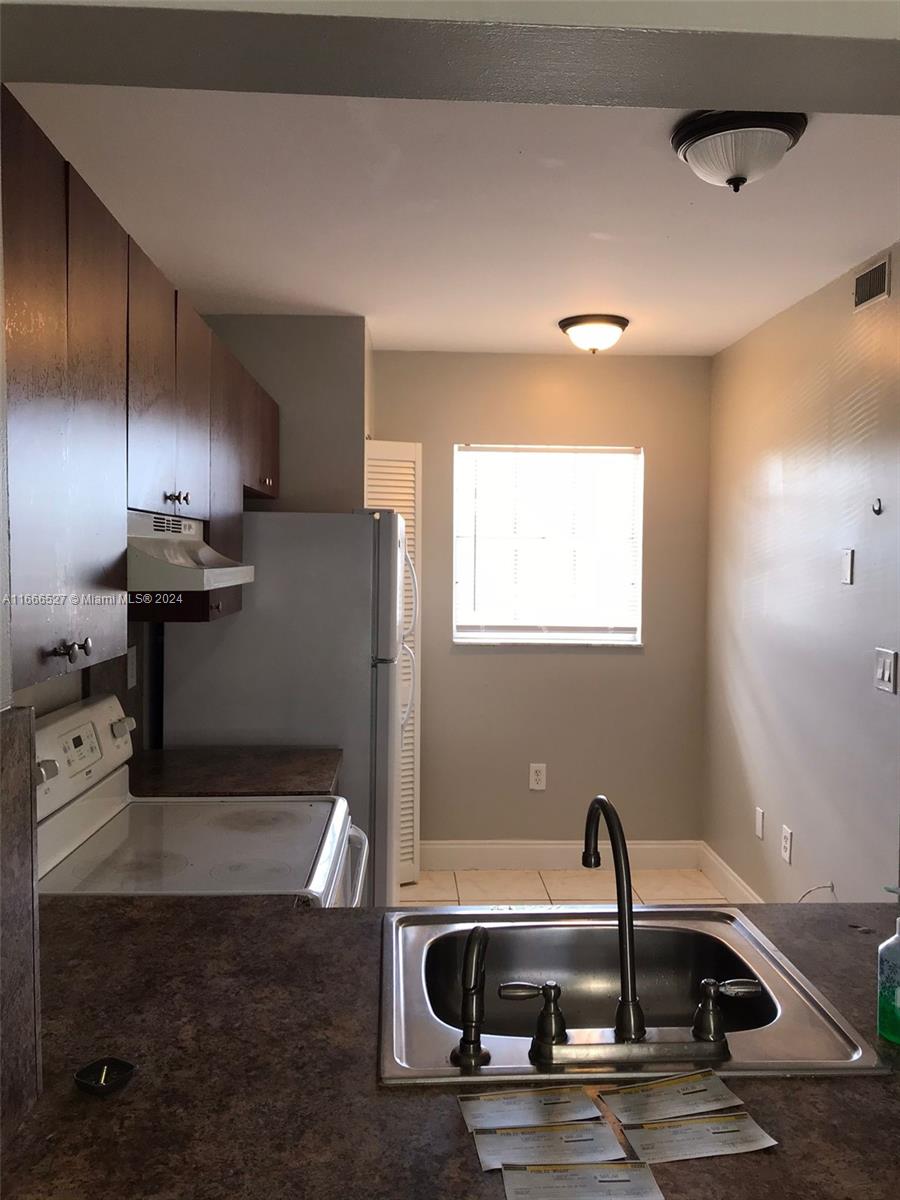 459 Northeast 210th Cir Terrace, Unit 20117 Miami, FL 33179 - Photo 21 of 33 a kitchen with a sink and stainless steel appliances