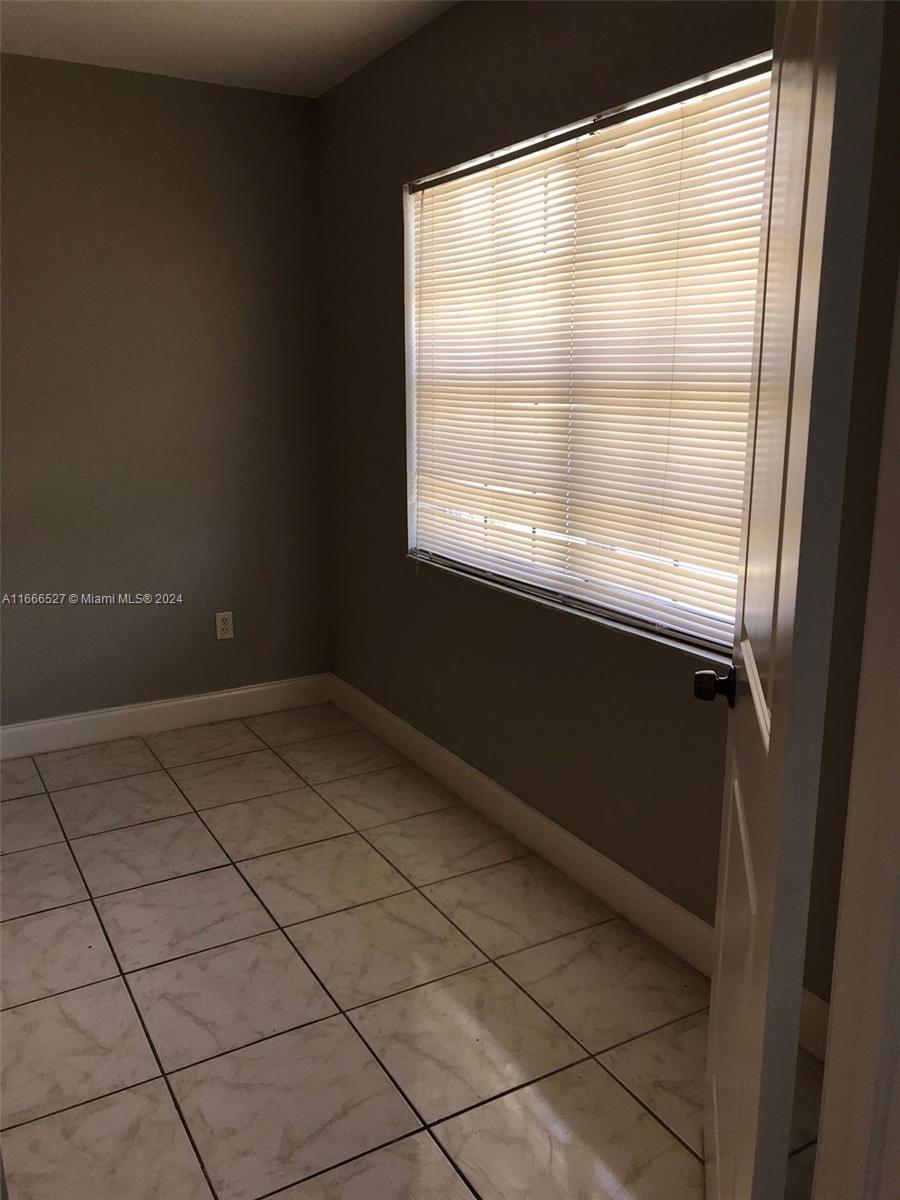 459 Northeast 210th Cir Terrace, Unit 20117 Miami, FL 33179 - Photo 23 of 33 a view of an empty room with a window