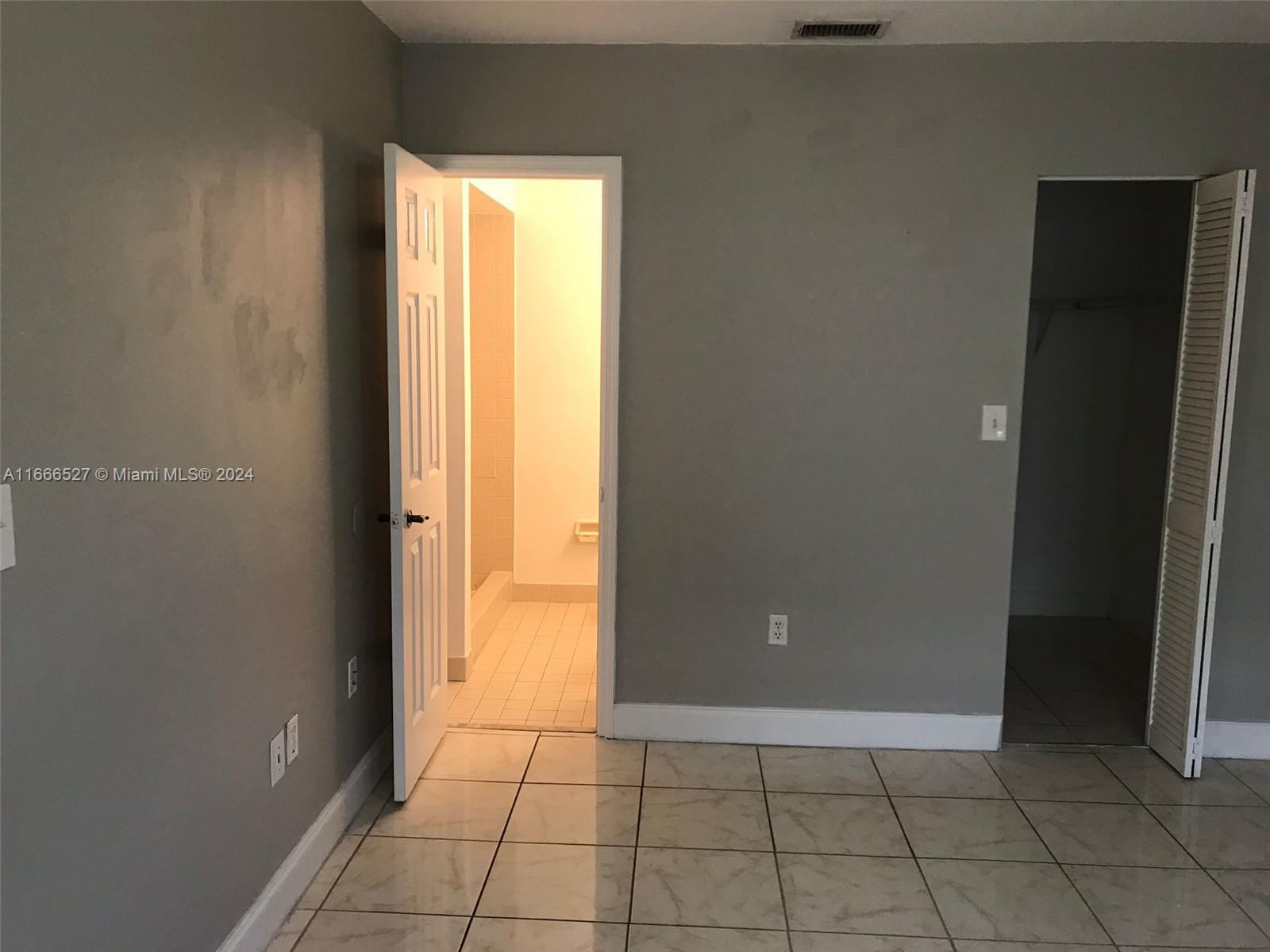 459 Northeast 210th Cir Terrace, Unit 20117 Miami, FL 33179 - Photo 26 of 33 an empty room with windows and closet