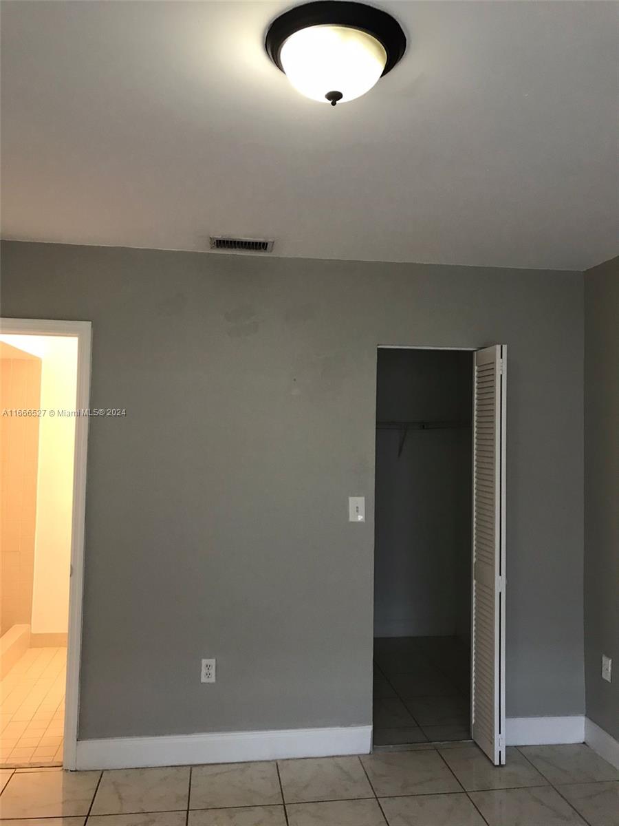 459 Northeast 210th Cir Terrace, Unit 20117 Miami, FL 33179 - Photo 27 of 33 an empty room with windows