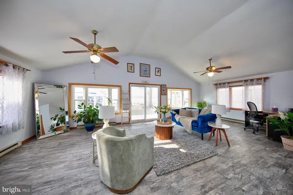 a living room with furniture a chandelier and a large window