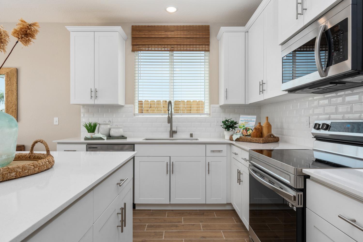 1167 Elevations Way West Madera, CA 93636 - Photo 11 of 28 a kitchen with cabinets appliances a sink and a window