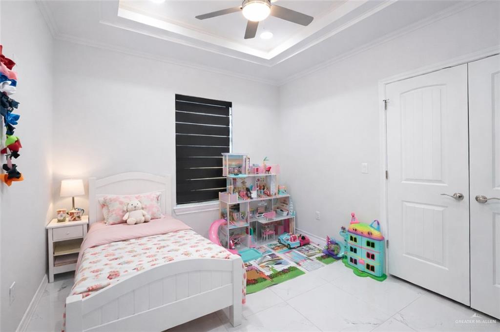 325 Dawn Street Rio Grande City, TX 78582 - Photo 13 of 17 a bedroom with a bed and a chandelier